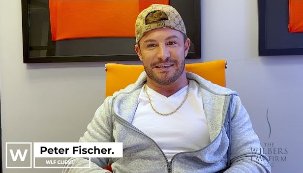 Man wearing a beige cap and gray hoodie sitting in an orange chair, identified as Peter Fischer, WLF client.